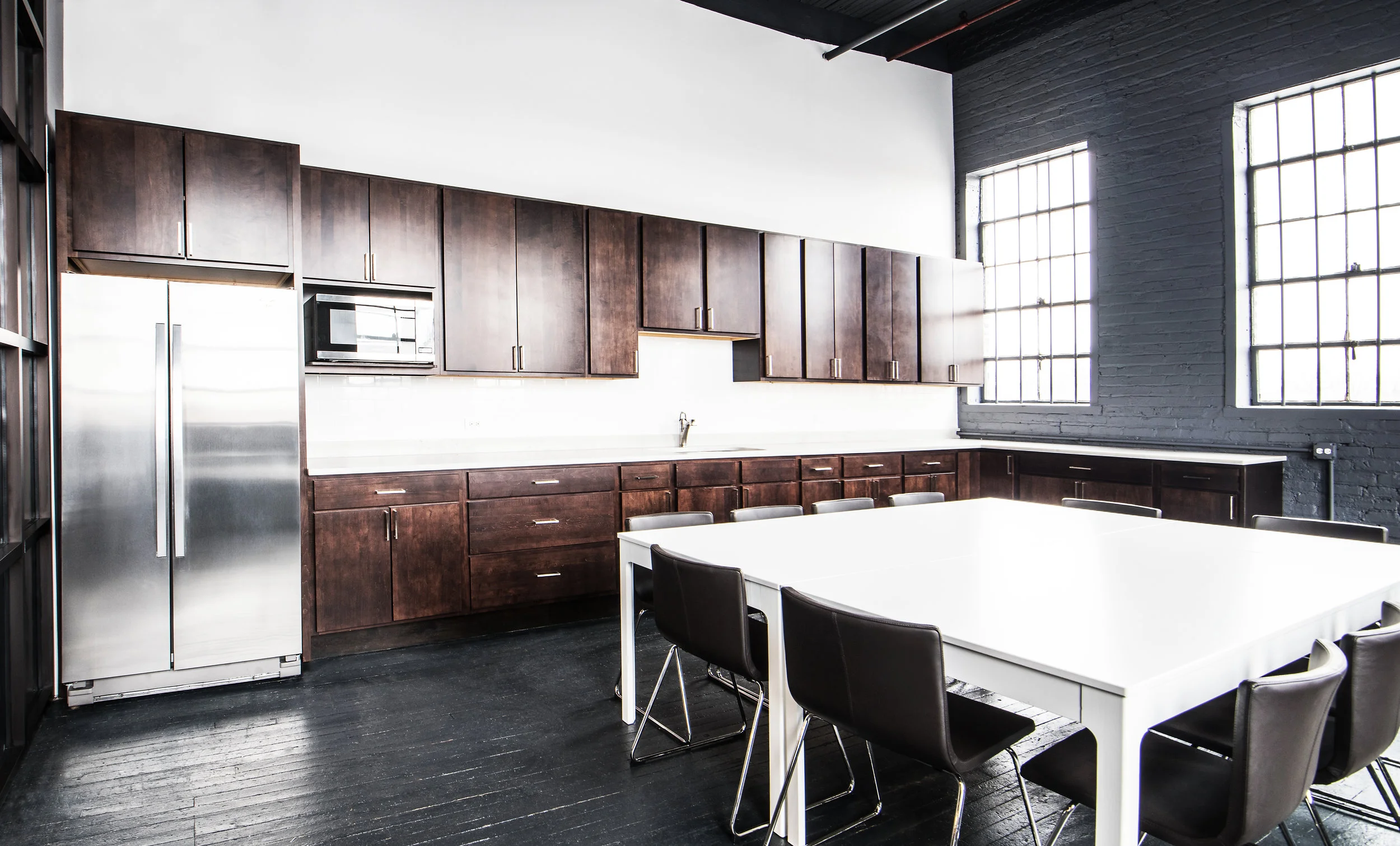 Secondary kitchen room at Stopover Studios with dark wood floors, daylight windows, and prep tables
